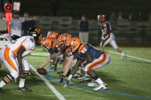 The offensive line gets set against Newton North.  (Photo courtesy of Greg Salvatore.)