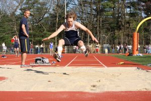 Junior Jackson Paslaski grabs some air in the long jump.