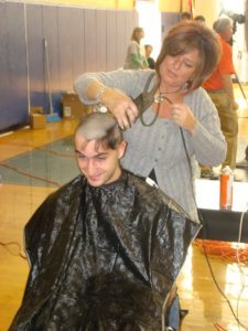 A Rebel football player shaves his head to raise money for Cancer Research.