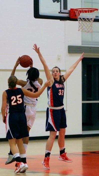 A Walpole player attempts to block a Wildcats shot.