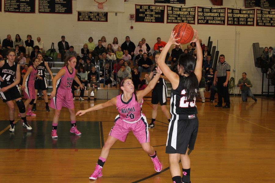 A Walpole player defends a Wellesley shooter.
