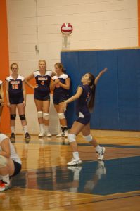 Walpole player serves the ball.