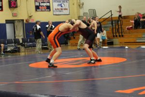 The Rebel's 220 lbs. wrestler ties up with his opponent. 