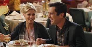 Claire and Phil laugh at dinner.