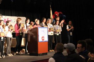 WHS Student Council President accepts Gold Council of Excellence Award on stage.