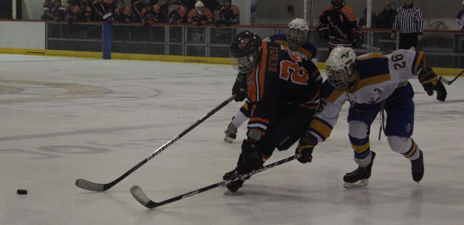 A Walpole and Norwood player battle for the puck.