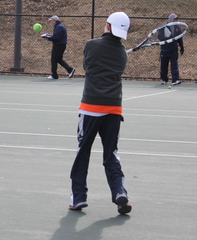 A tennis player warms up with a forehand.