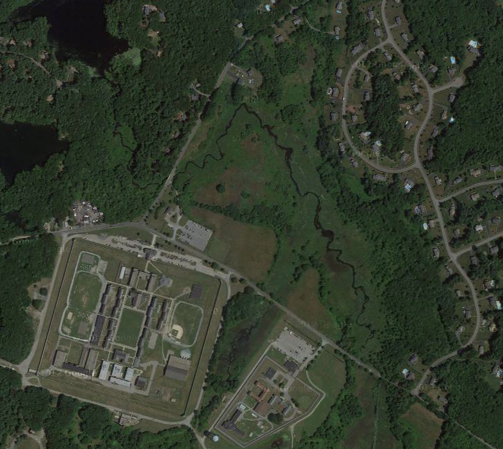The large square of land is the Walpole prison, with the fields being the lighter green land in the center.