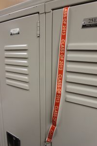 Student Council members hang lanyards on the seniors' lockers as a gift
