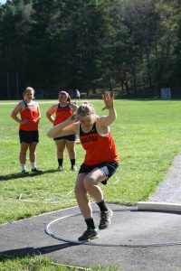A member of the Walpole Track and Field Team throws a shot put.