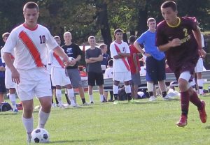 A Walpole midfielder dribbles the ball away from a defender.