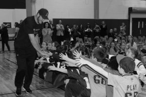 A New England Patriots player high-fives students at Elm Street School.