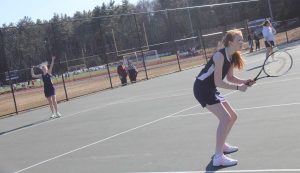 A Walpole doubles team serves against Milton. 