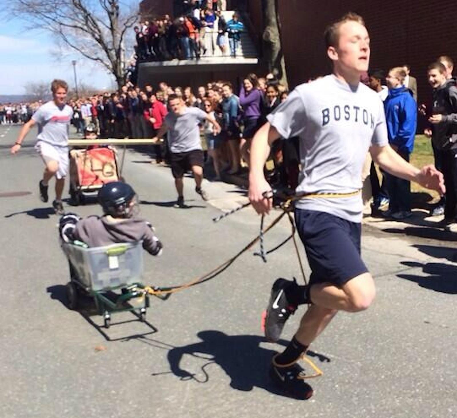 Walpole students compete against St. Sebastian in the chariot races at Holy Cross.