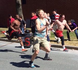 A Walpole student competes in the chariot races.