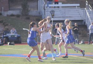 Walpole player dodges around a Natick defender.