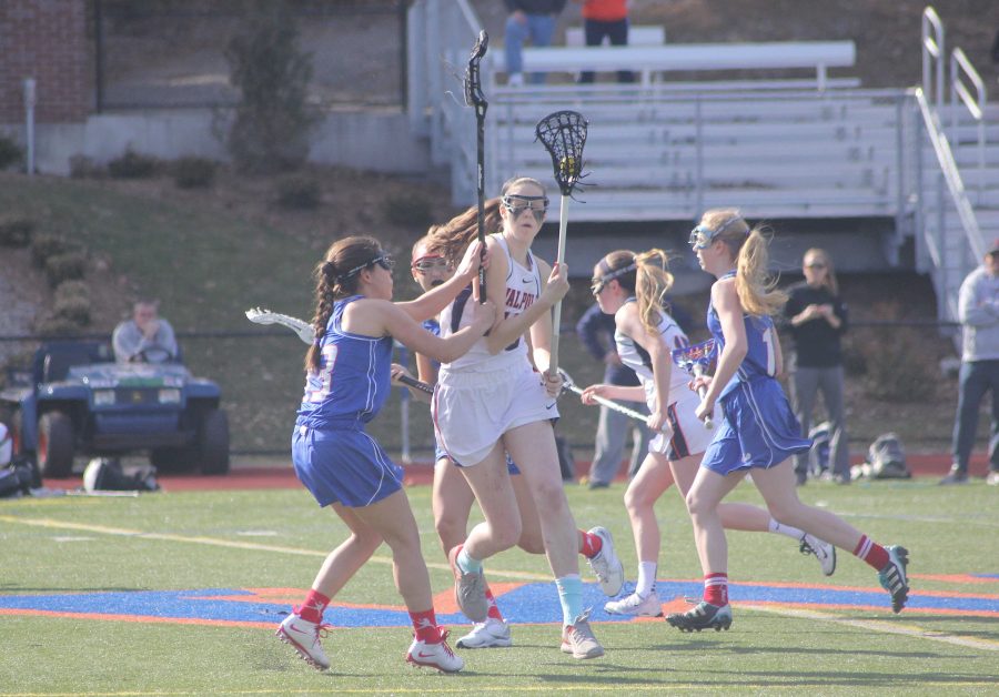 Walpole player dodges around a Natick defender.