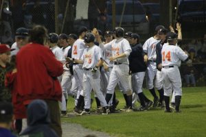 The Rebels huddle in between innings later in the game.