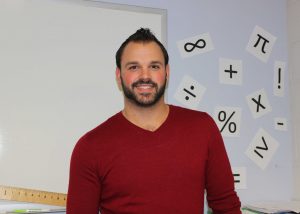 Mr. Okolowitcz smiles for a picture in his classroom.