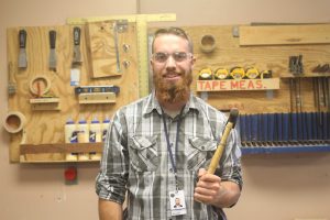 Mr. Reale poses for a photo in the wood shop.