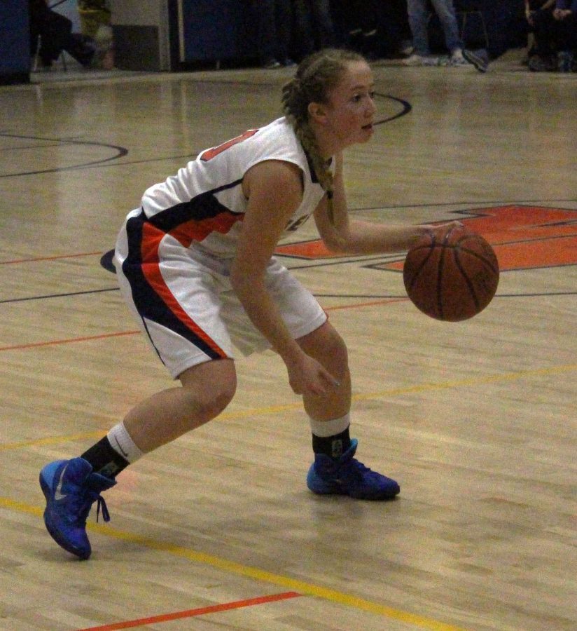 A Walpole athlete dribbles the ball down the court.