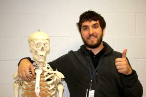 One arm around his classroom skeleton, science teacher Mr. O'Connor gives a thumbs-up (Photo/ Emily Butler, Dana DeMartino, and Kerstin Fontanez).