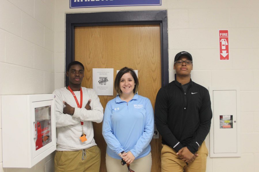 Randall poses outside of her office with students Raynal Louissaint and Reggie Michel.