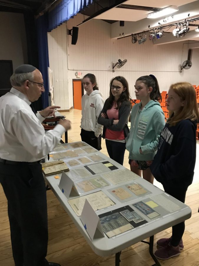 After the presentation, Blechner speaks to 8th grade girls in front of the artifacts he brought.