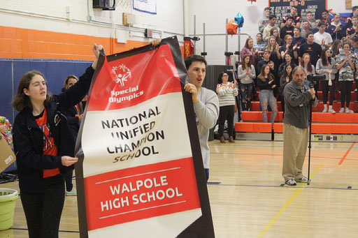 Students carry National Unified Champion banner during the pep rally.