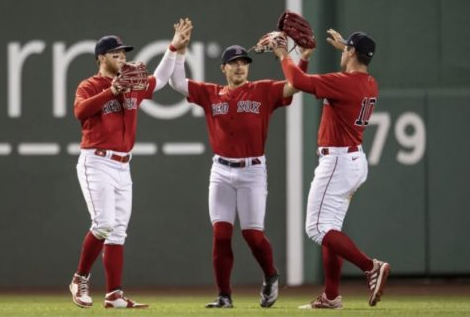 Hernandez (middle) celebrates in the outfield prior to the Red Soxs outbreak