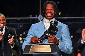 A picture of Travis Hunter holding the Heisman trophy.